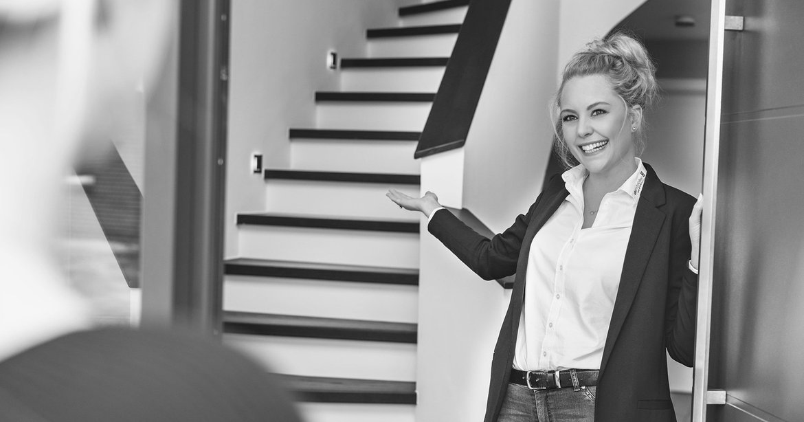 Mitarbeiterin von ah immobilien öffnet Kunden die Haustür